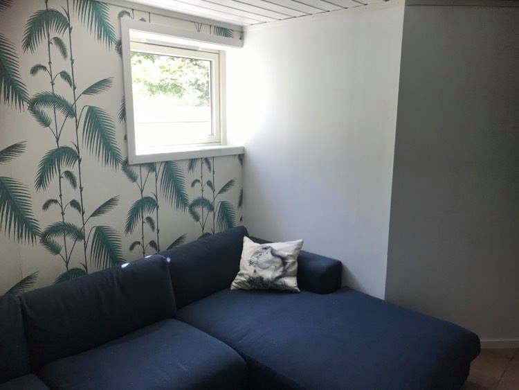 Stuen har stor sofa som følger med og vindu mot hagen. Det syns ikke på bildet, men det er også en liten peisovn i hjørnet av rommet. Galleribilde