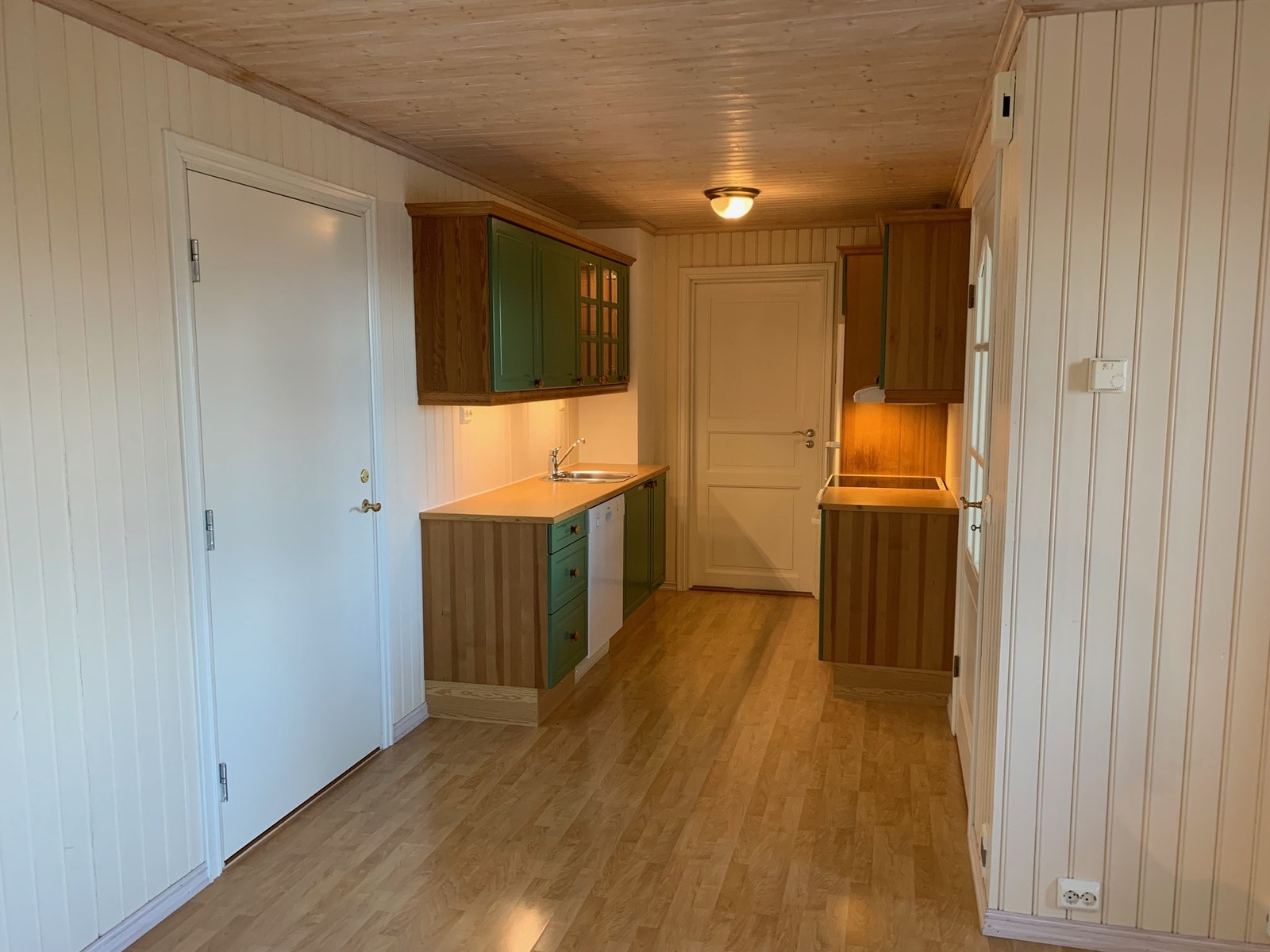 Åpen kjøkkenløsning mot stue. Kjøkken har kjøl/frys, oppvaskmaskin og komfyr. Galleribilde