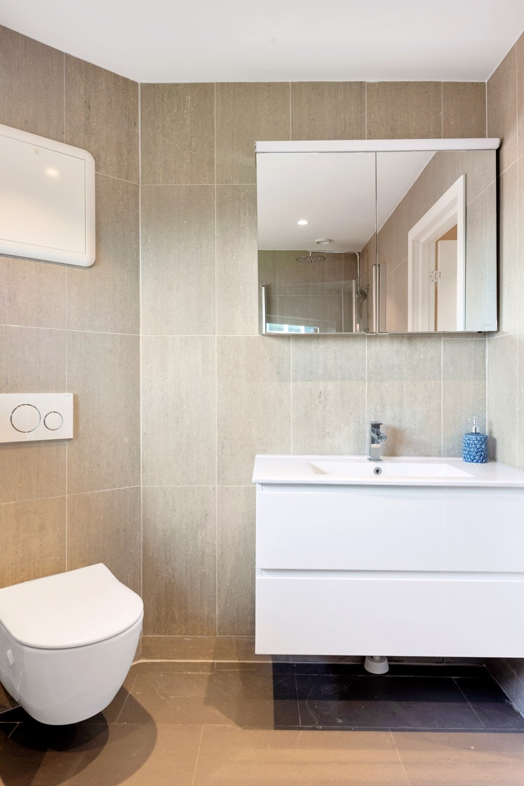 Flislagte overflater på vegger og gulv, himling med glatte malte flater og innfelte downlights i himlingen Galleribilde