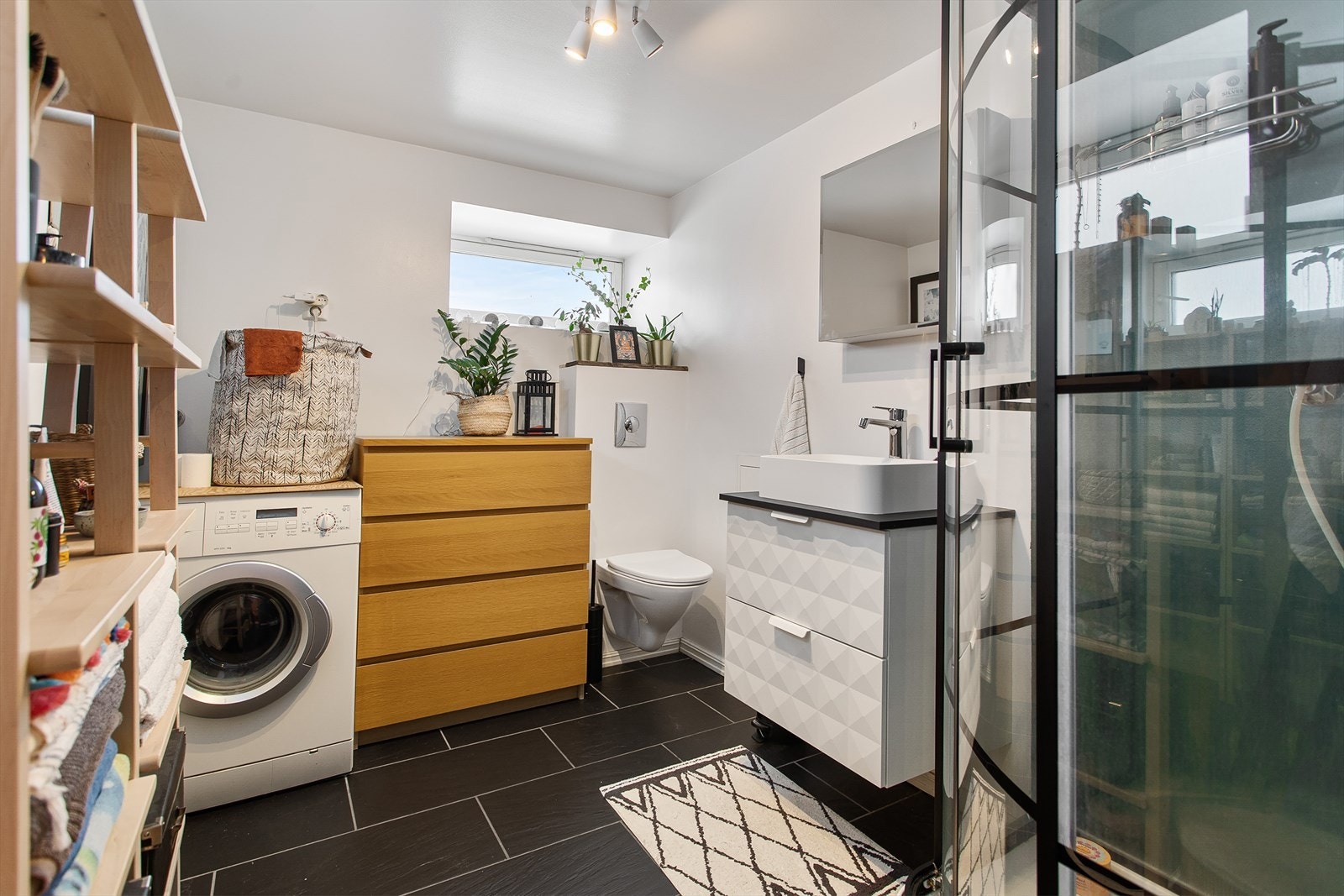 Badet er flislagt med gulvvarme, og har servant, toalett og dusj. I tilegg er det opplegg for vaskemaskin. Galleribilde