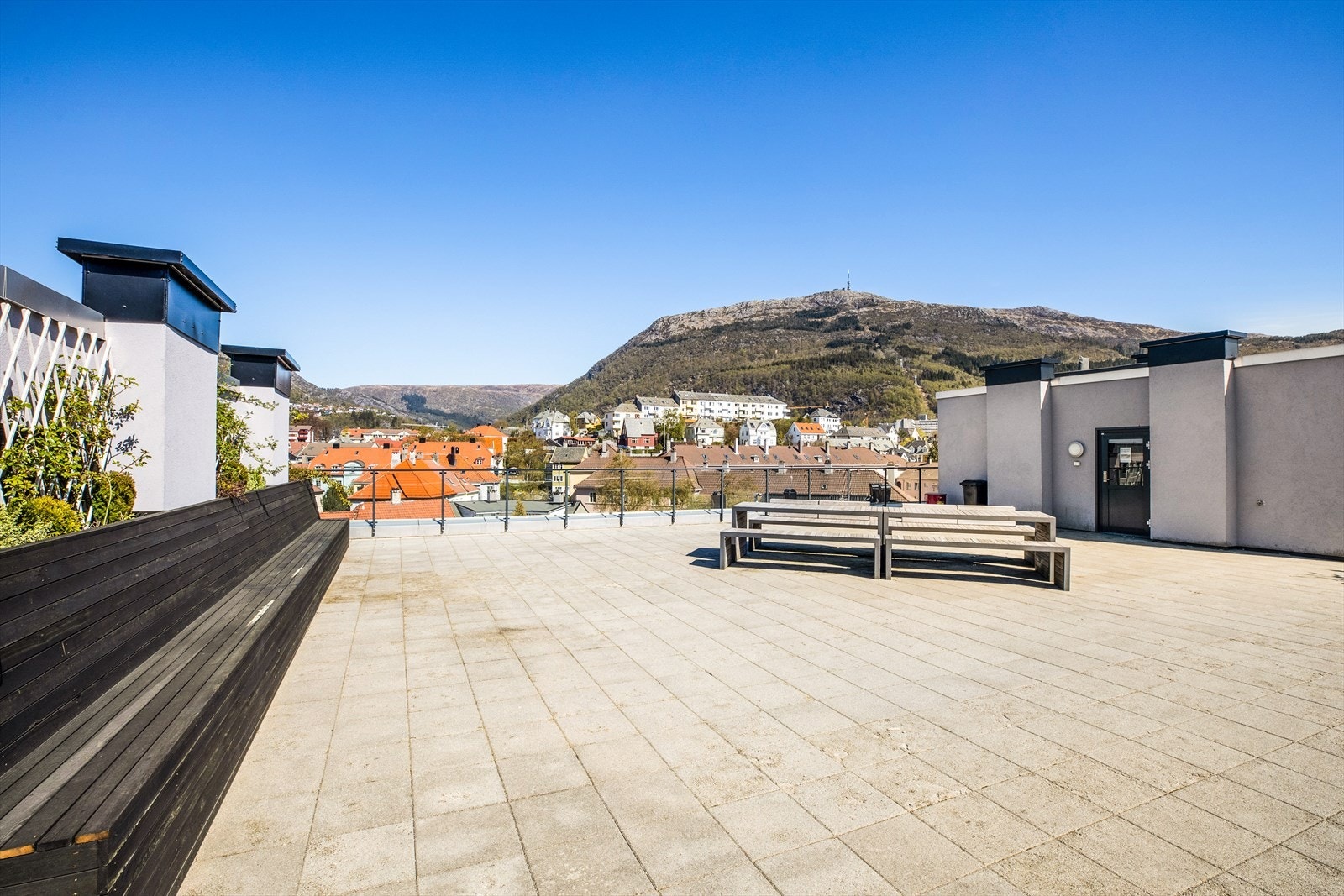 Stor felles takterrasse, som er utstyrt med møbler og planter. Galleribilde