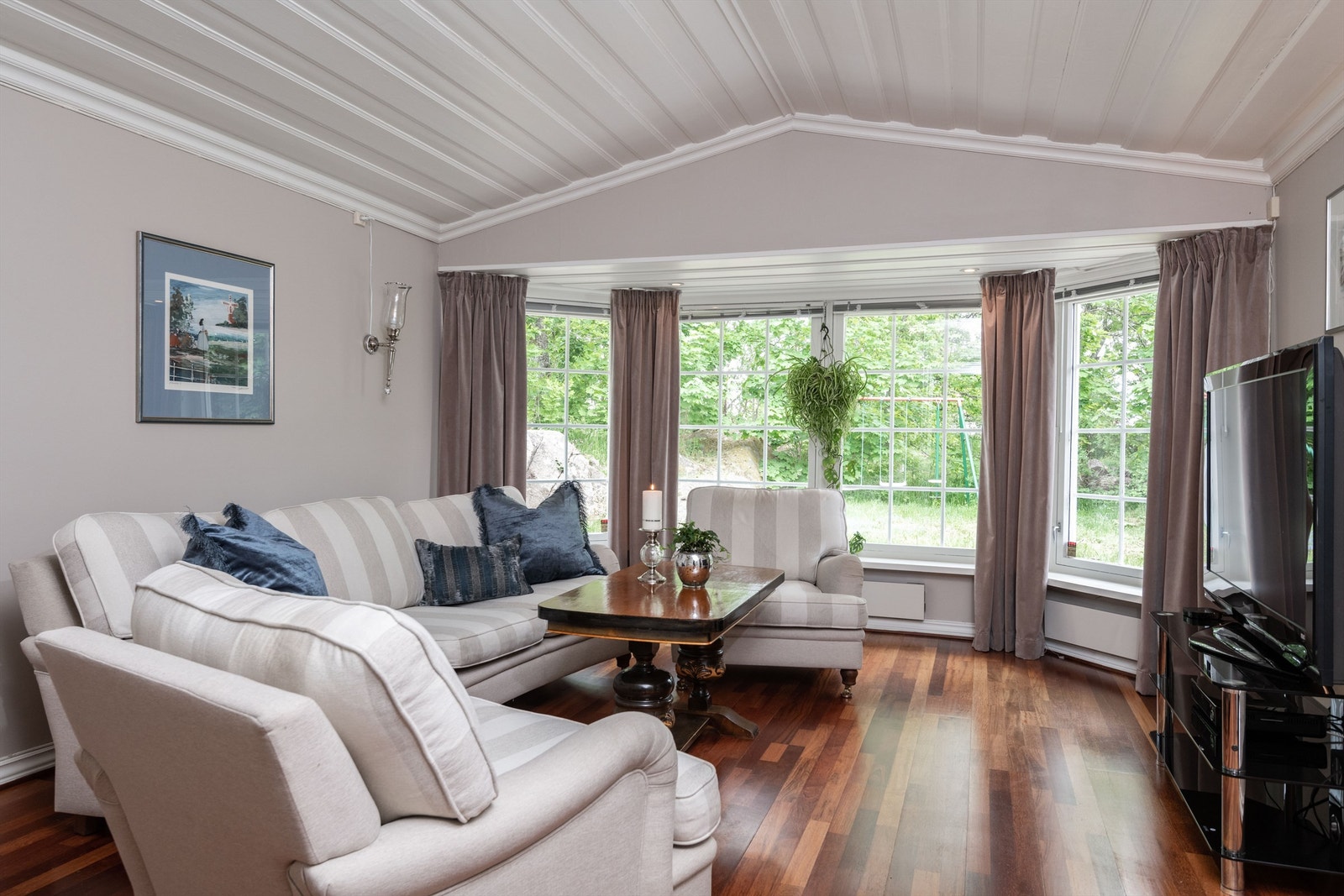 En romslig TV-stue med fint utsyn mot hagen. Galleribilde