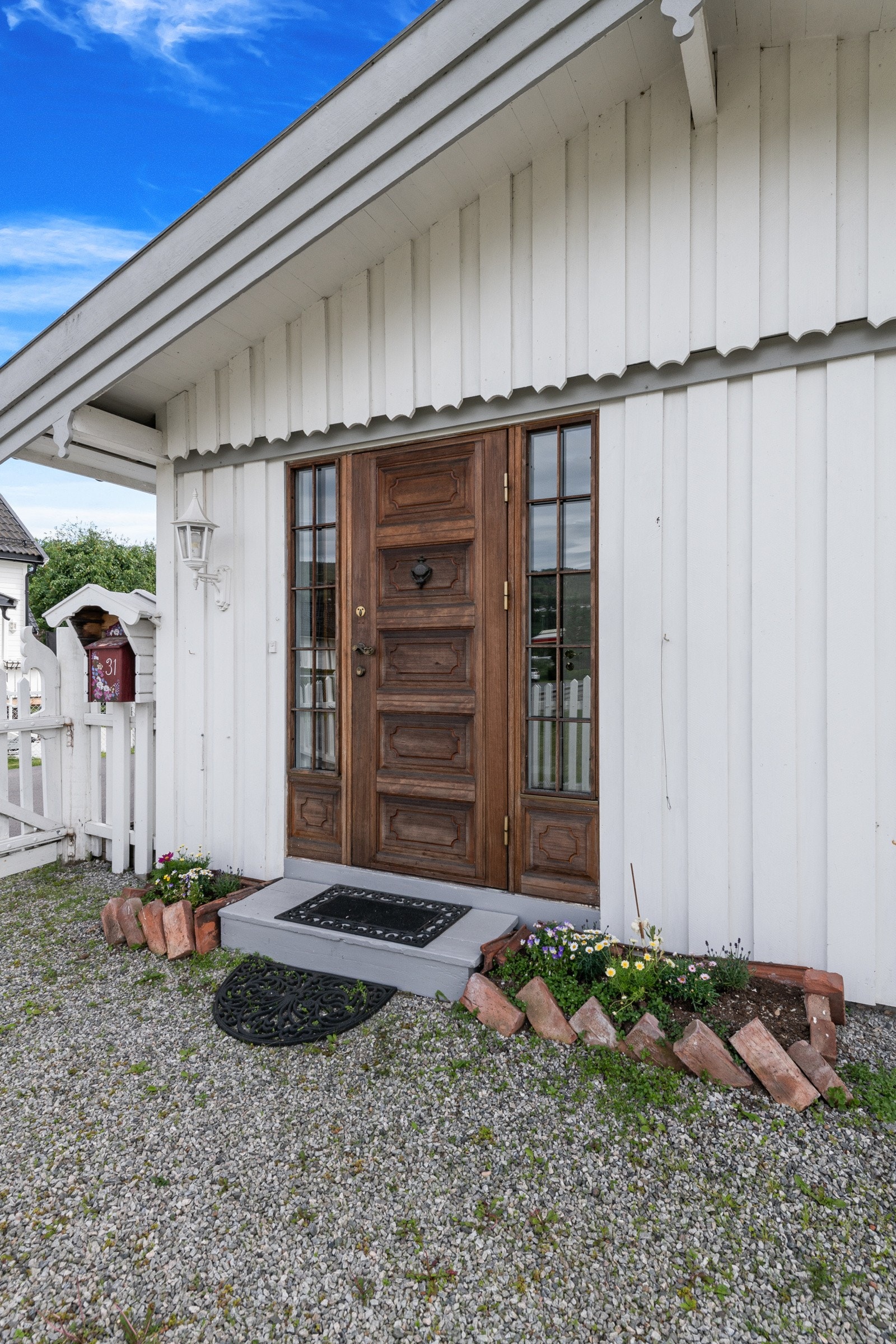 Boligen har et inngangsparti under takutspring, med høyreiste vinduer til profilert ytterdør. Galleribilde