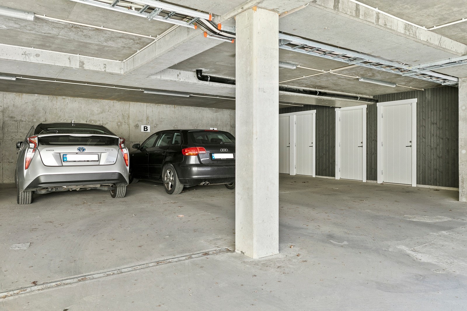 Parkeringplass i åpen garasjekjeller. Galleribilde