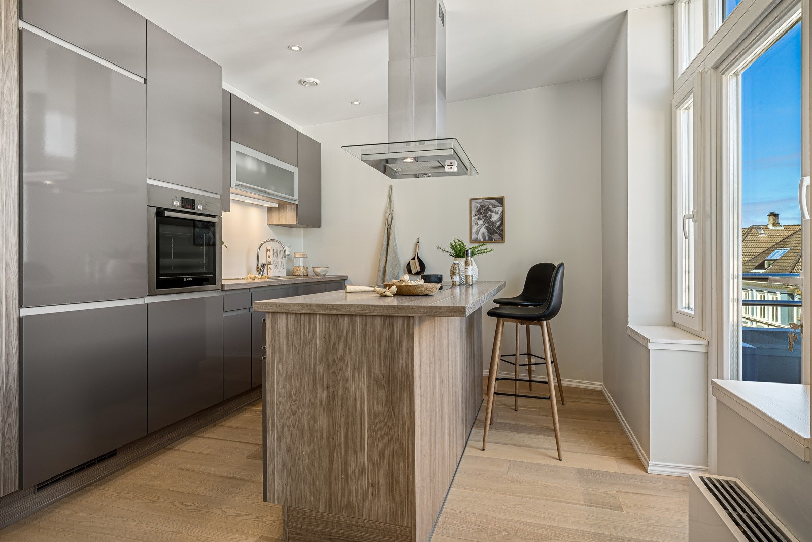 Videre har kjøkkenøy platetopp (induksjon) og fritthengende ventilator med hette i stål/glass. Galleribilde