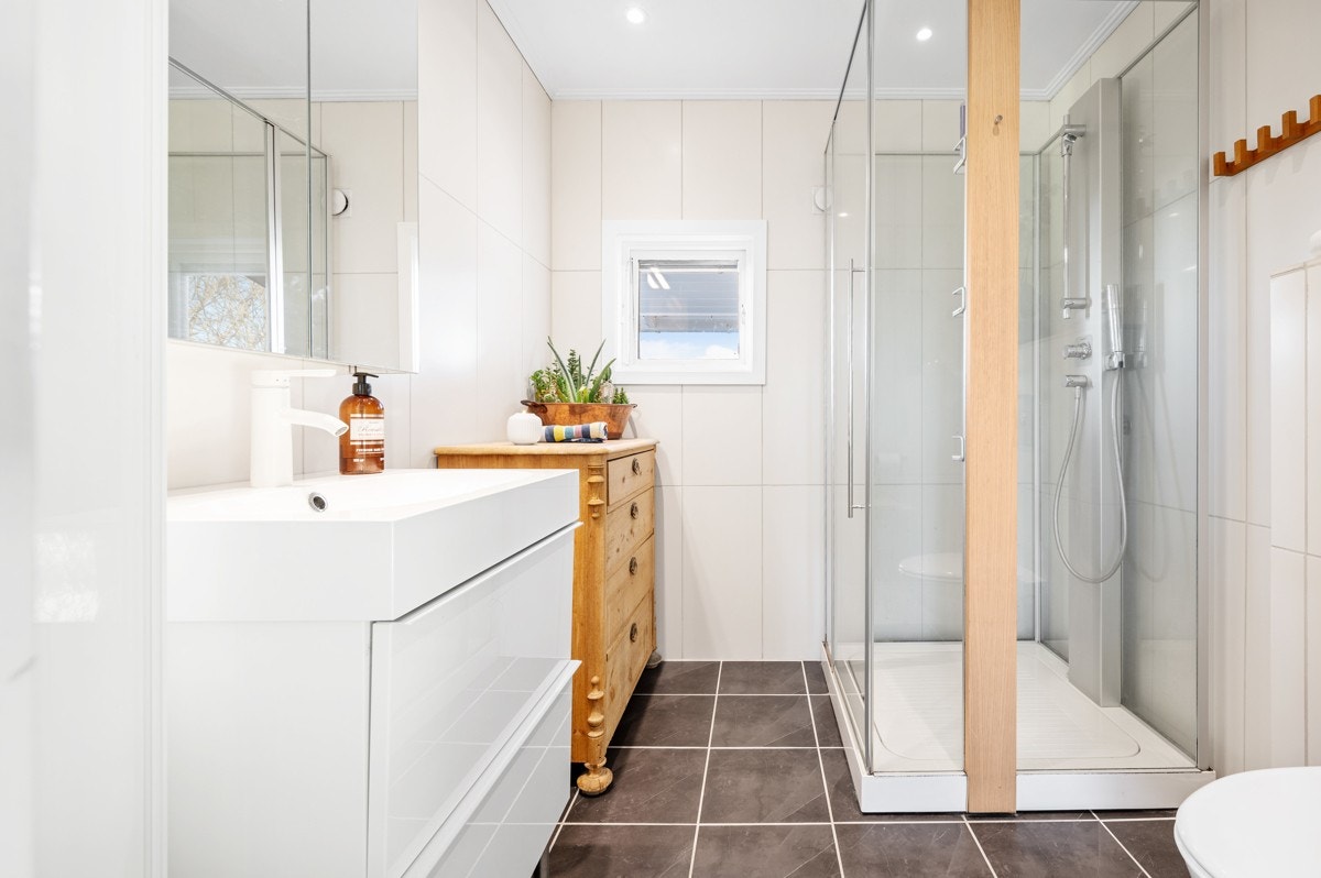 Vegghengt speilskap med lys og moderne servant med glatte fronter. Galleribilde