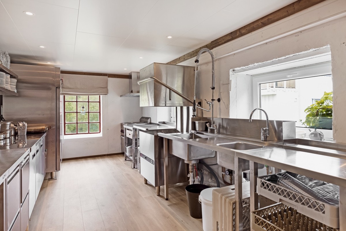 Stort industrikjøkken i forbindelse med private sosiale rom/selskapsavdeling. Galleribilde