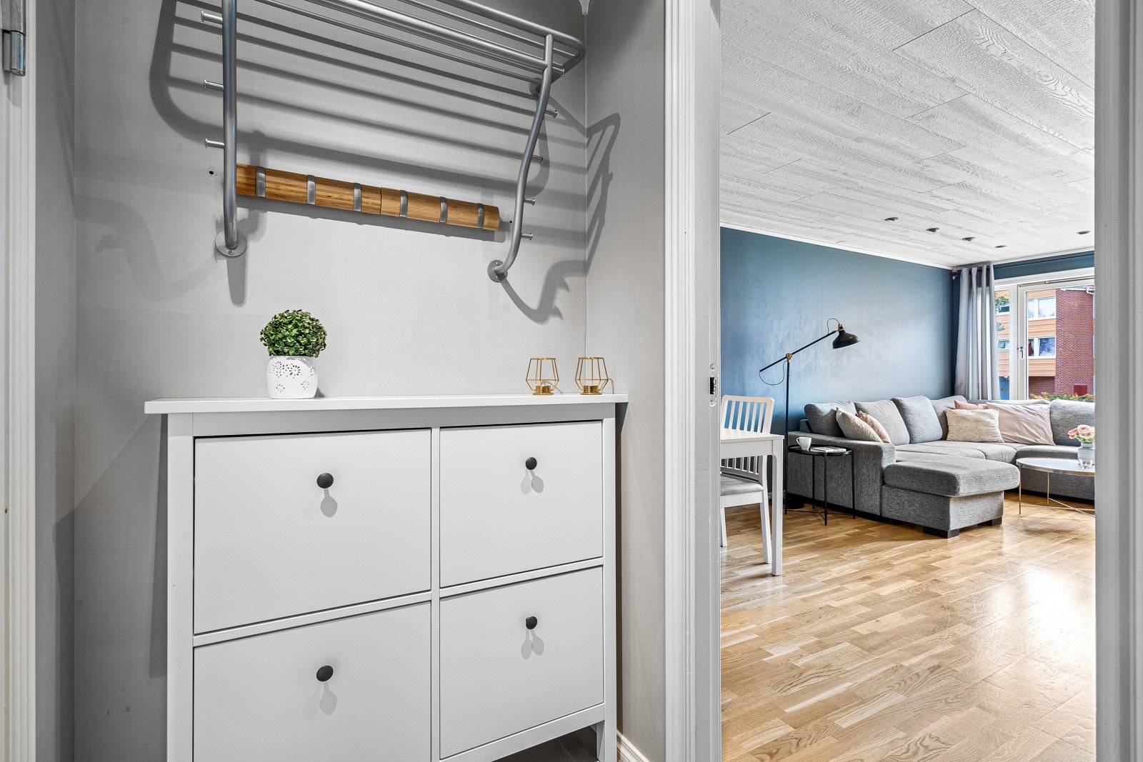 Inngangspartiet er flislagt med downlights i himling og plass til oppheng av yttertøy og sko Galleribilde