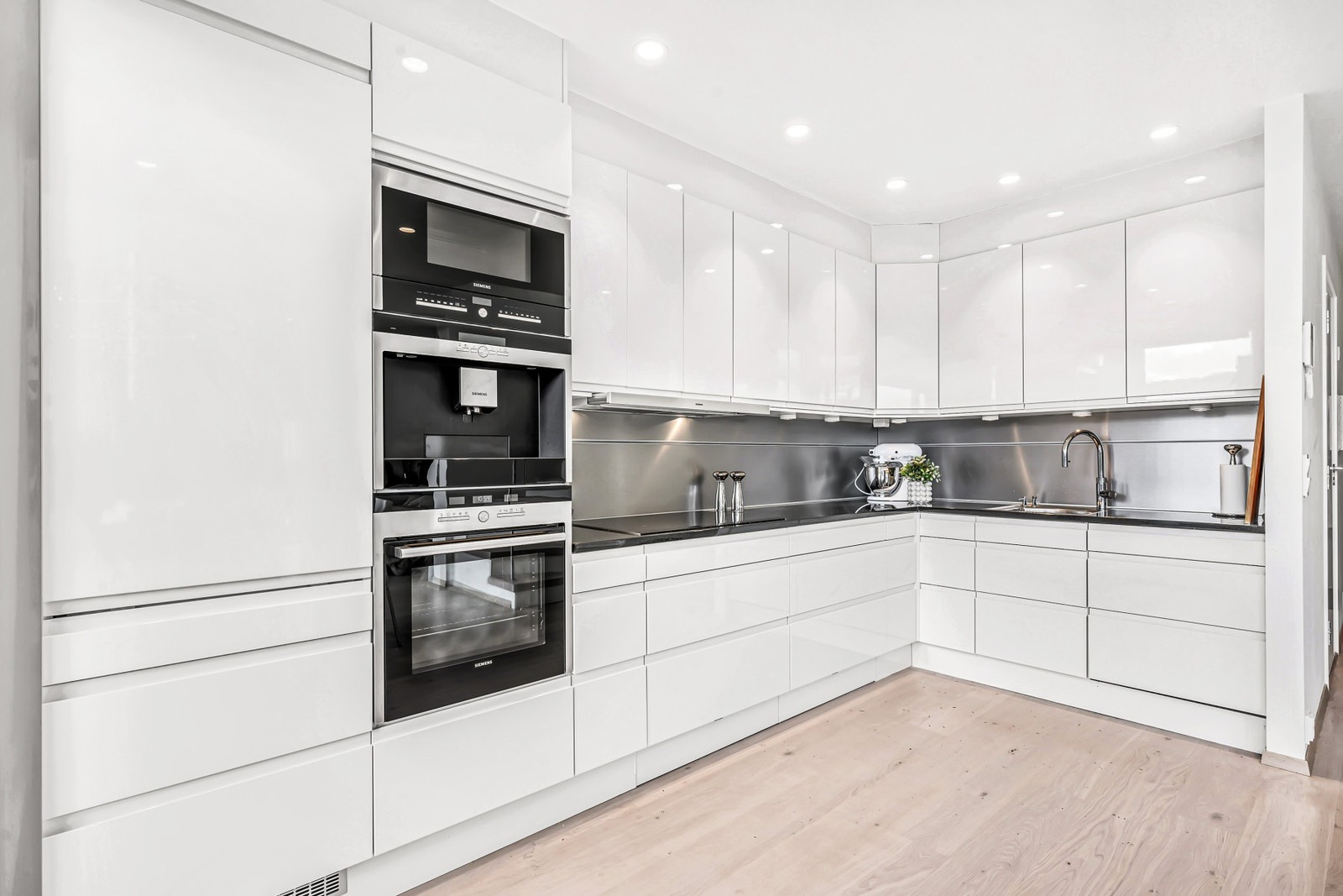 Stilrent kjøkken med benkeplate i stein og integrerte hvitevarer. Kjøkkenet har fått TG1 fra takstmann. Galleribilde