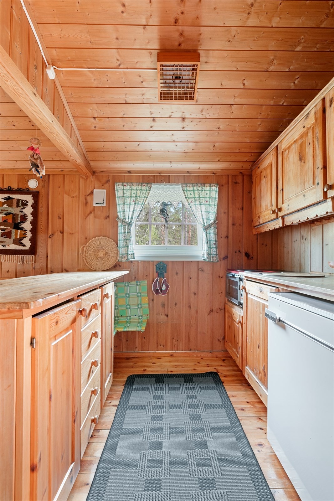 Kjøkken med innredning og benkeplate i heltre furu. Luke i gulv til kjølerom. Galleribilde