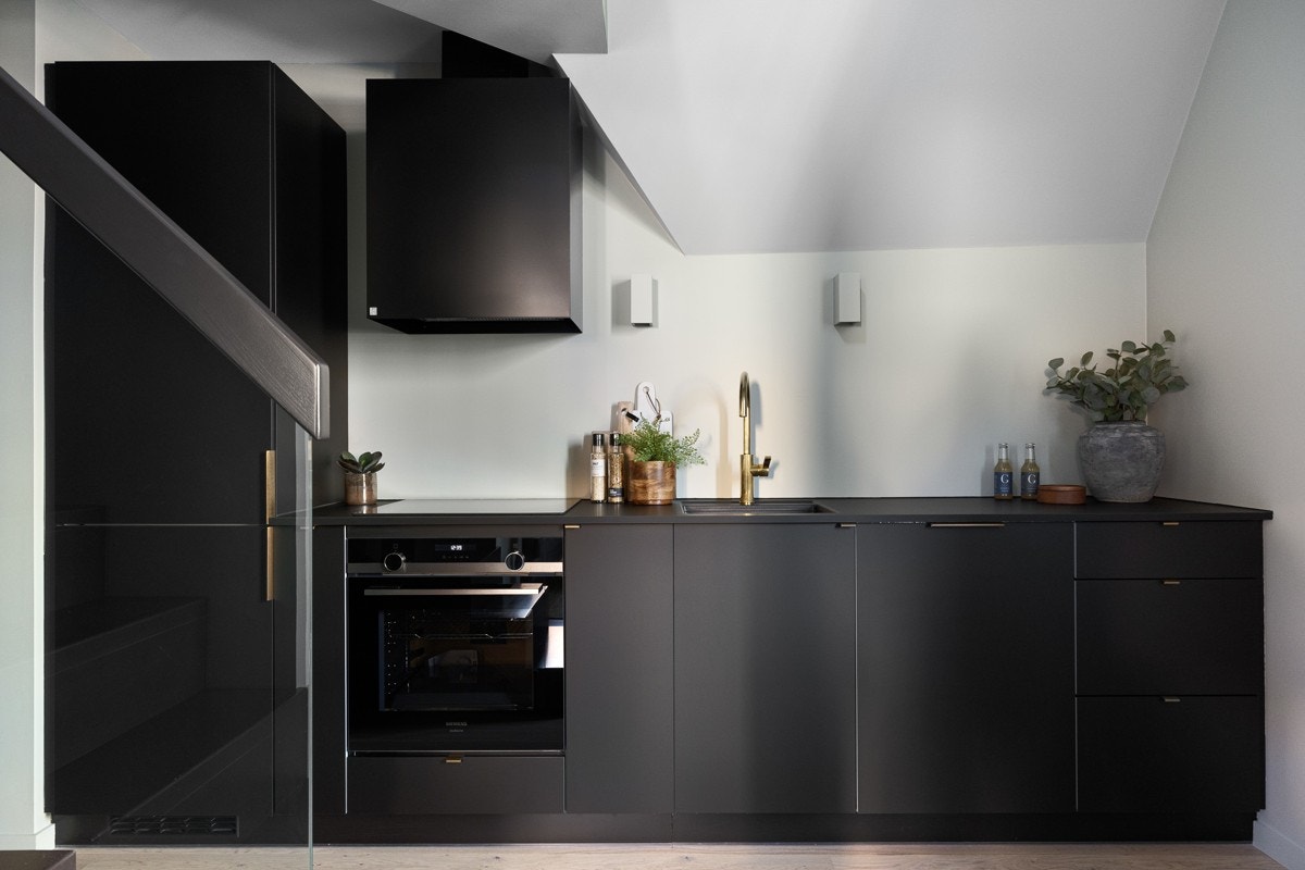 Kjøkkenet har ny og moderne innredning fra Kvik, med glatte, mørkfolierte fronter og benkeplate med planlimt oppvaskkum. Galleribilde