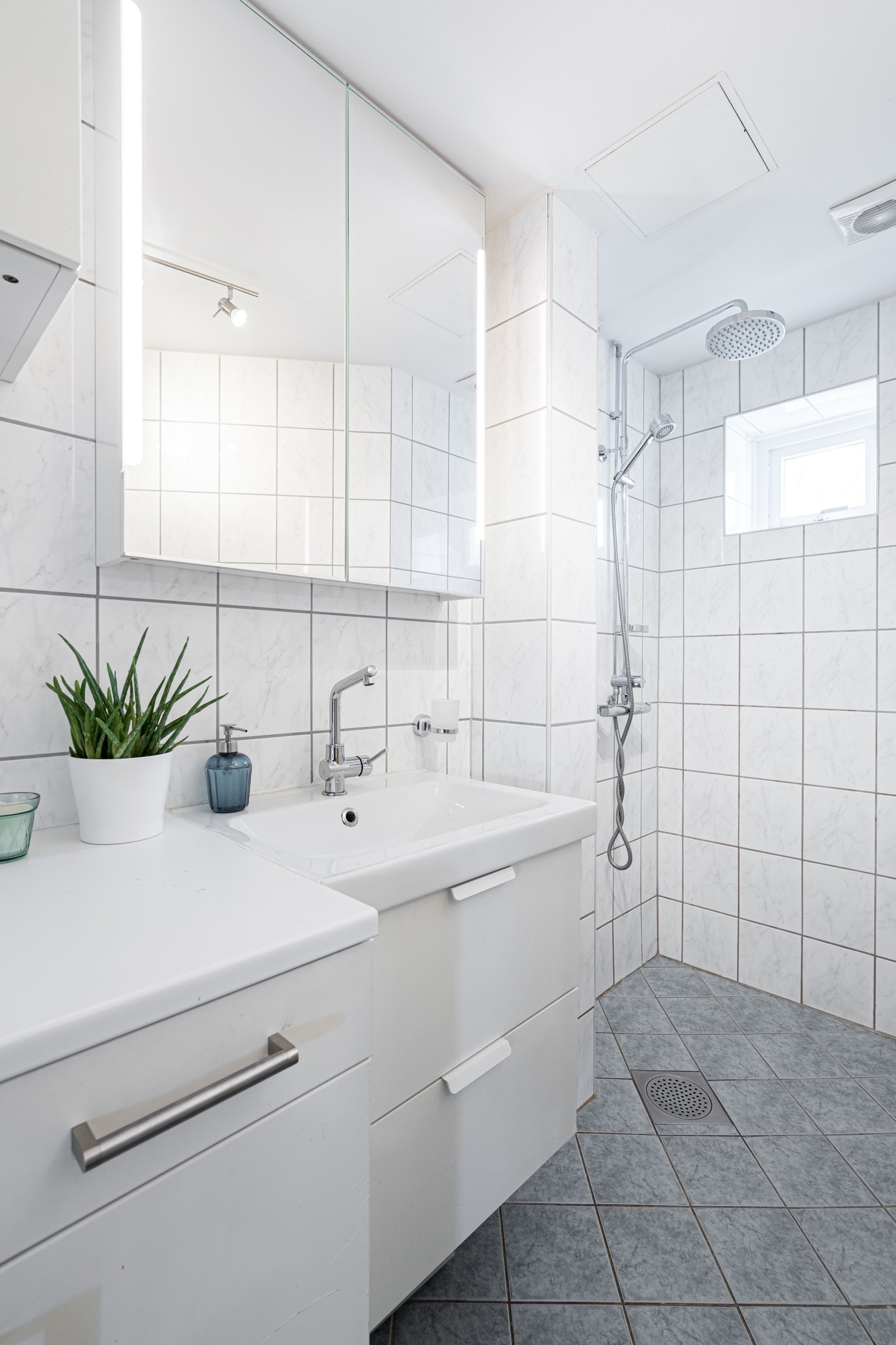 Baderomsinnredningen består av dusjnisje, skapinnredning, servantinnredning og overskap med speilfronter og belysning. Galleribilde