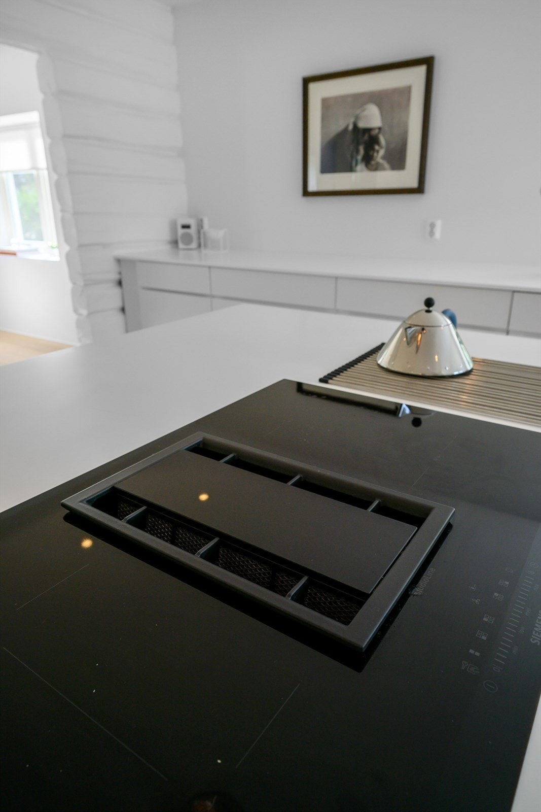 Praktisk kjøkkenøy med mye oppbevaringsplass og mulighet for barstoler. Galleribilde