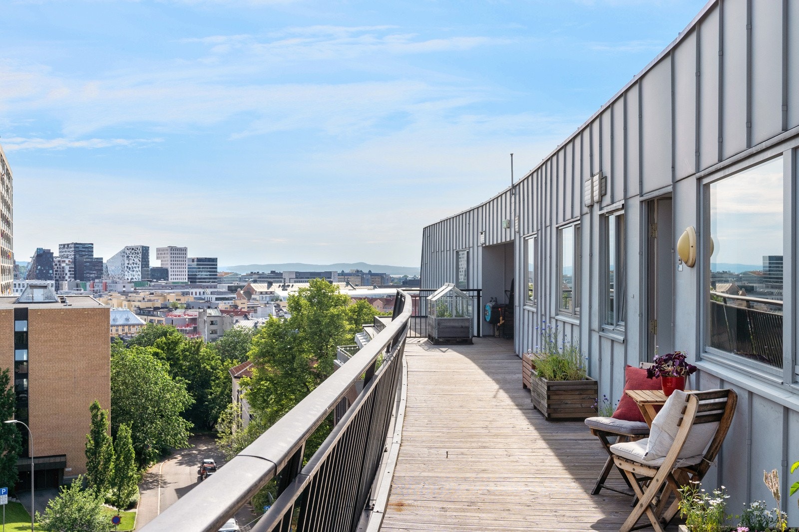 Plass til en liten sittegruppe på svalgangen ved inngangspartiet, med morgensol og utsikt til Barcode. Galleribilde