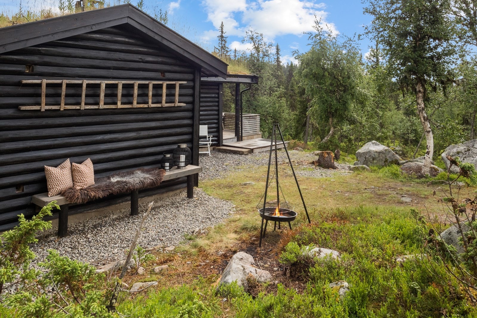 Uteområdet er nylig gruset og har flere hyggelige sitteplasser. Her kan ettermiddagssola nytes ved bålpanna. Galleribilde