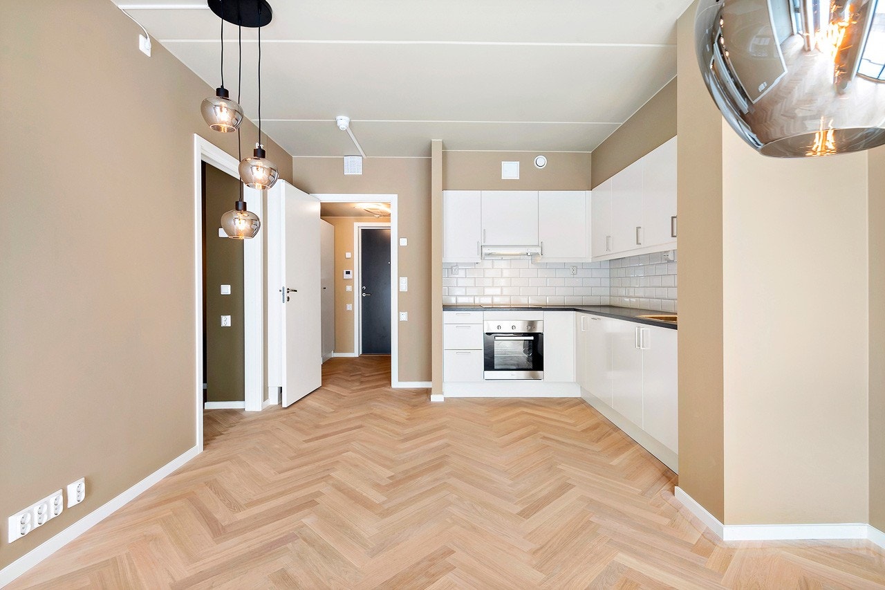 Stue med åpen kjøkkenløsning + integrerte hvitevarer Galleribilde