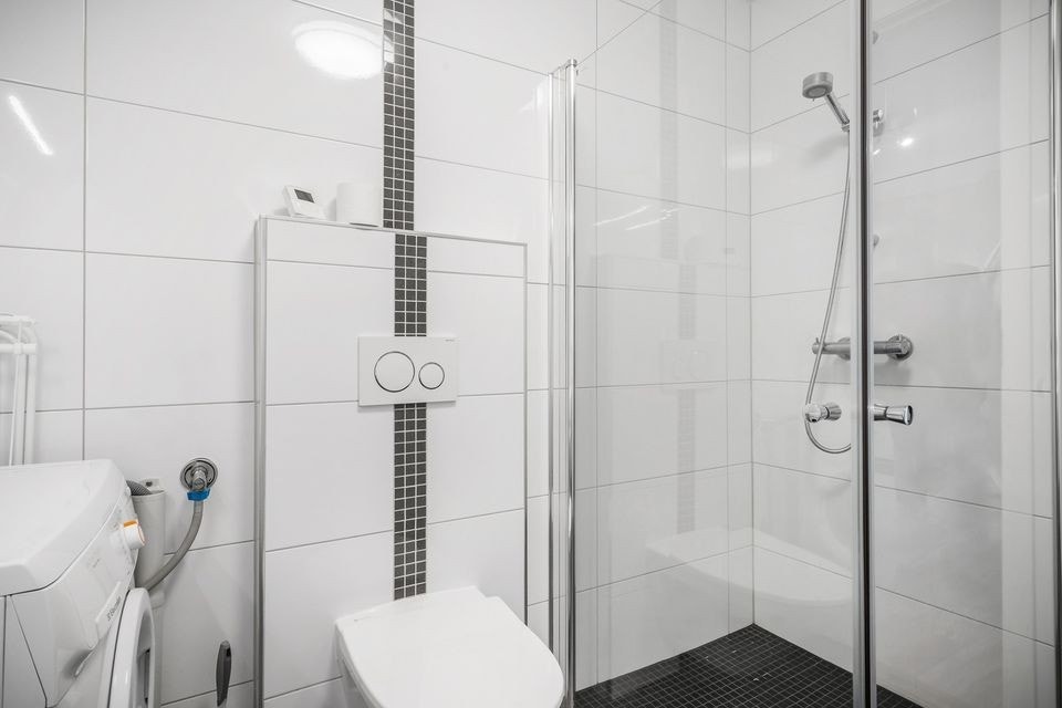 The bathroom is furnished with shower, toilet, washbasin and arrangement for washing and dry machine. Galleribilde