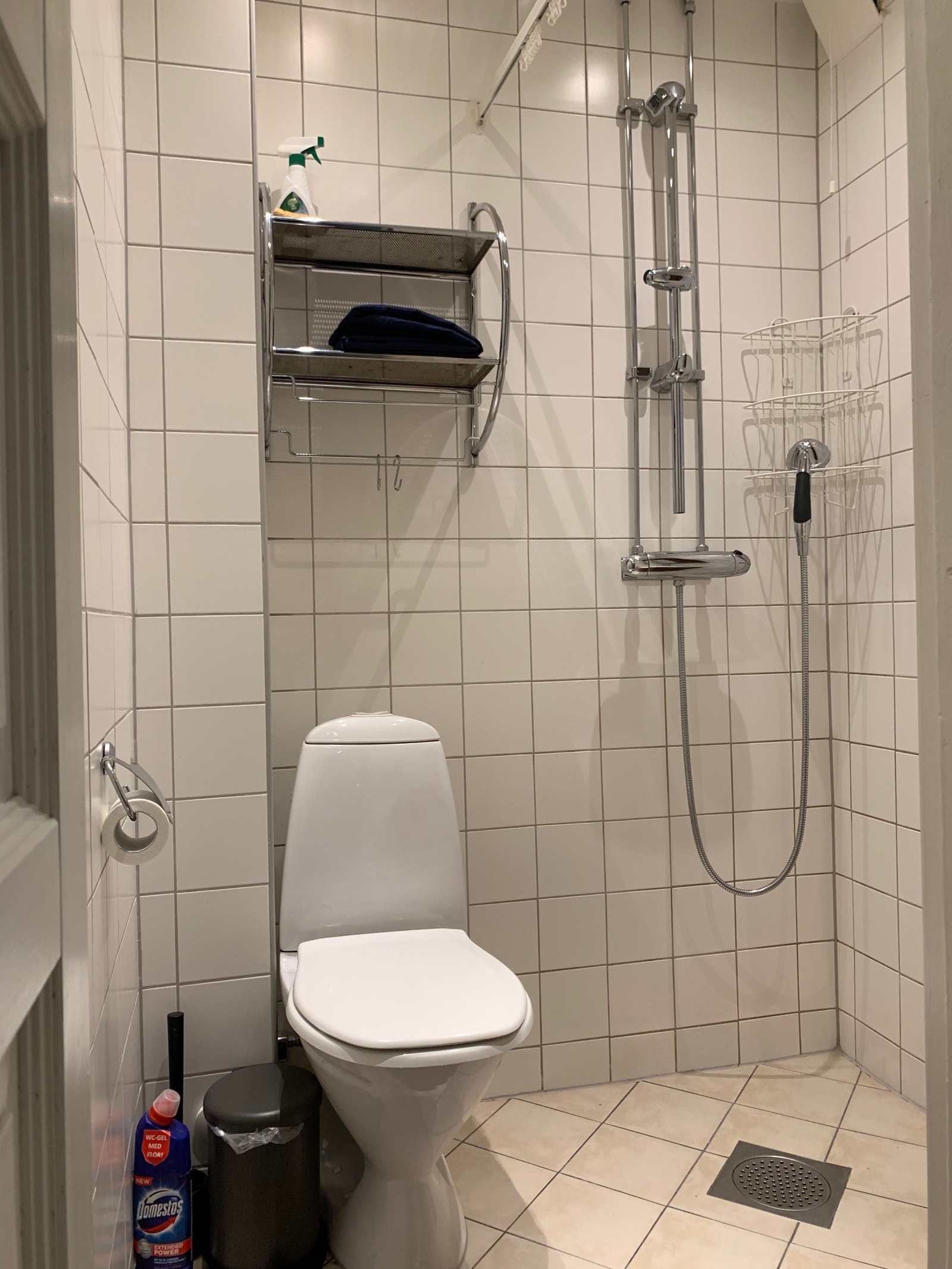 Effektivt bad med varmekabler, toalett, dusjnisje med forheng, vask med speil og under-og overskap Galleribilde