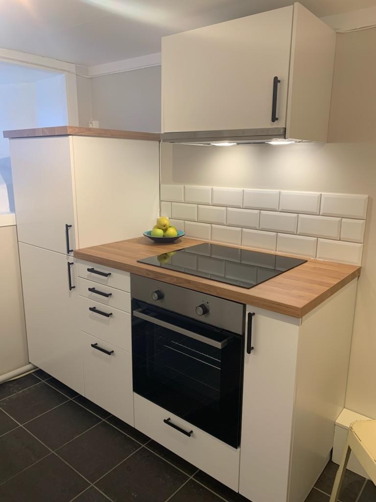 Kjøkken med komfyr og kjøleskap m/ lite fryserom øverst. Galleribilde