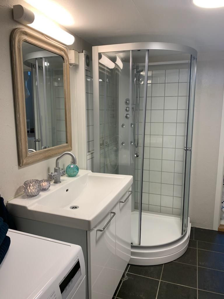 Baderom med vaskemaskin og dusjkabinett. Galleribilde