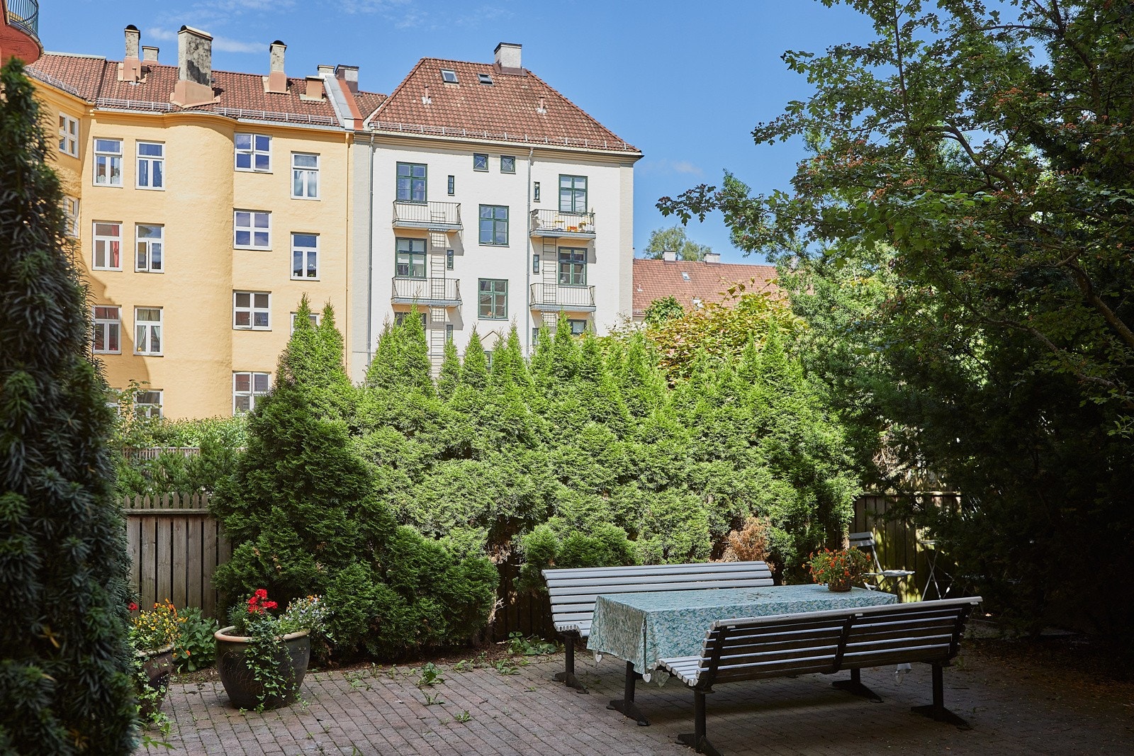 Bakgården er opparbeidet med belegningsstein, sittegrupper, sykkelparkering, busker og beplantning. Galleribilde