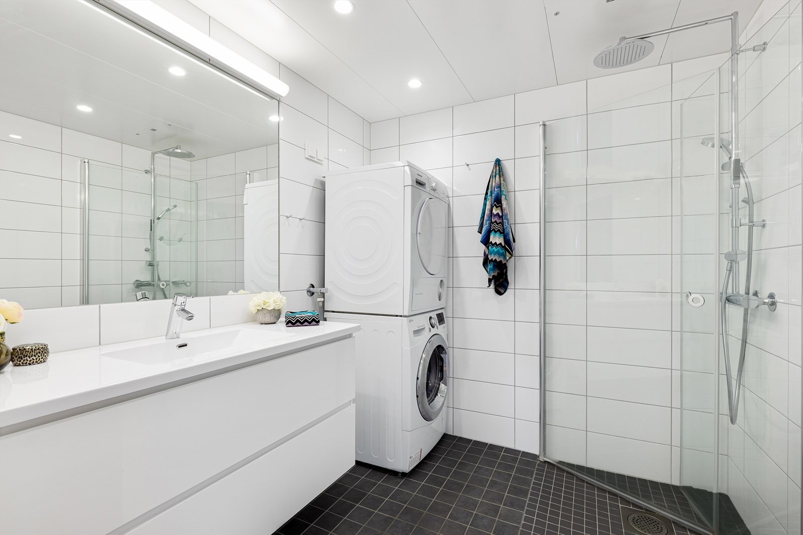 Bad 2: Pent bad med dusjhjørne, stor servant med skuffer, vegghengt wc og speil. Galleribilde