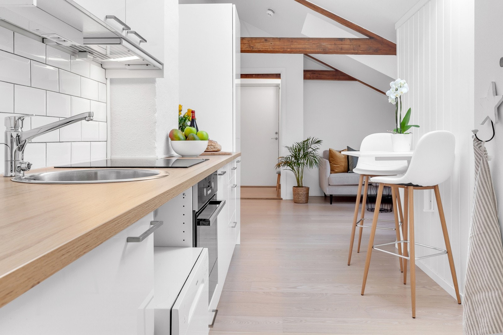 Tidløs kjøkkeninnredning med integrert stekeovn, induksjonstopp og kjøle-/fryseskap. Galleribilde