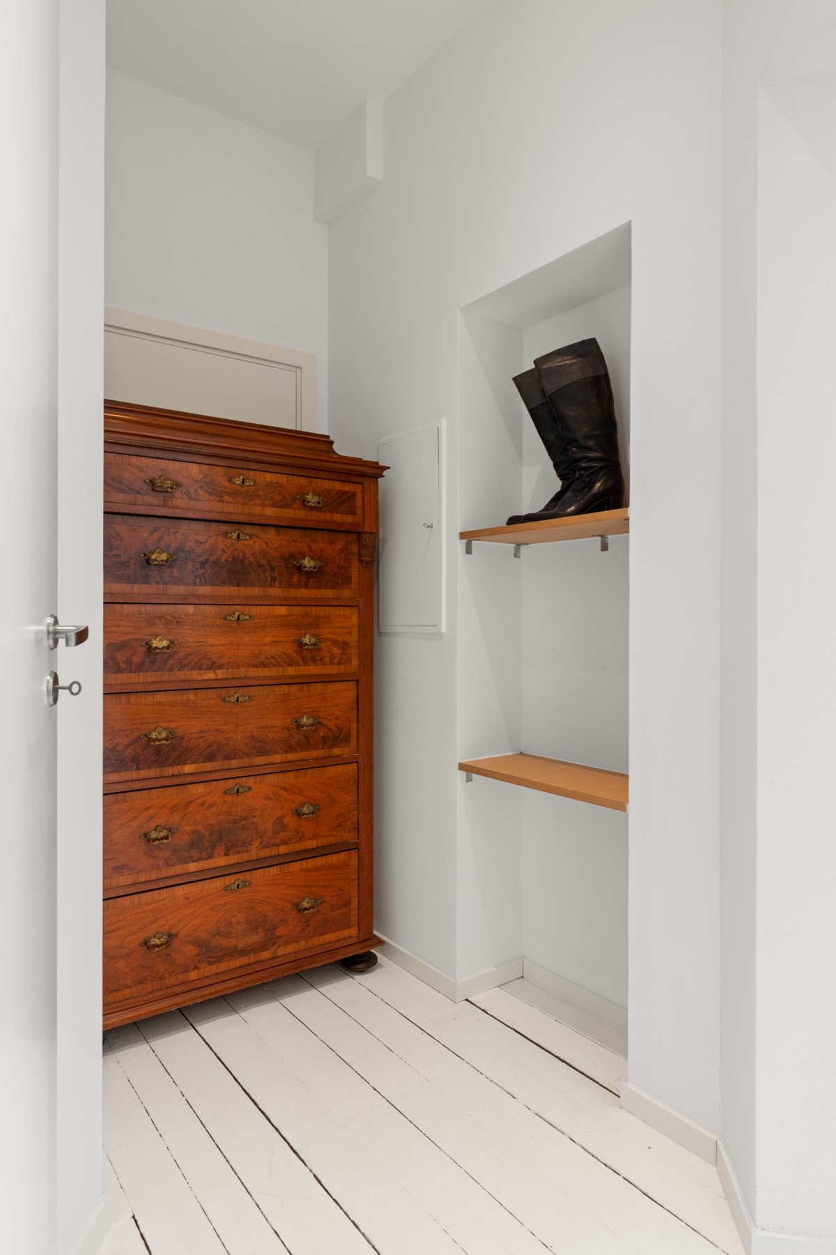 Mellomgangen før hovedsoverom har plass til hyeller og kommode for ekstraoppbevaring, bak kommoden skjules dør som kan åpnes hvis man selv vil bruke arealet fra utleidel/praktikantdel. Galleribilde