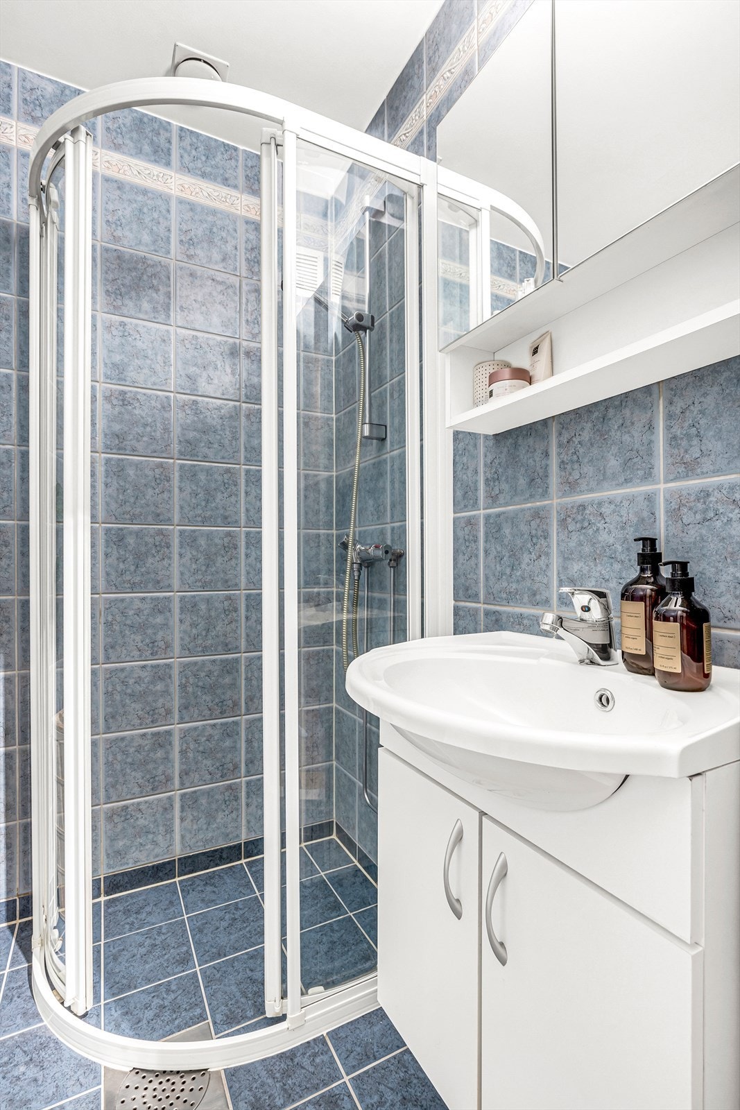 Badet er innredet med dusjhjørne, servant med underskap, speilskap og wc. Galleribilde