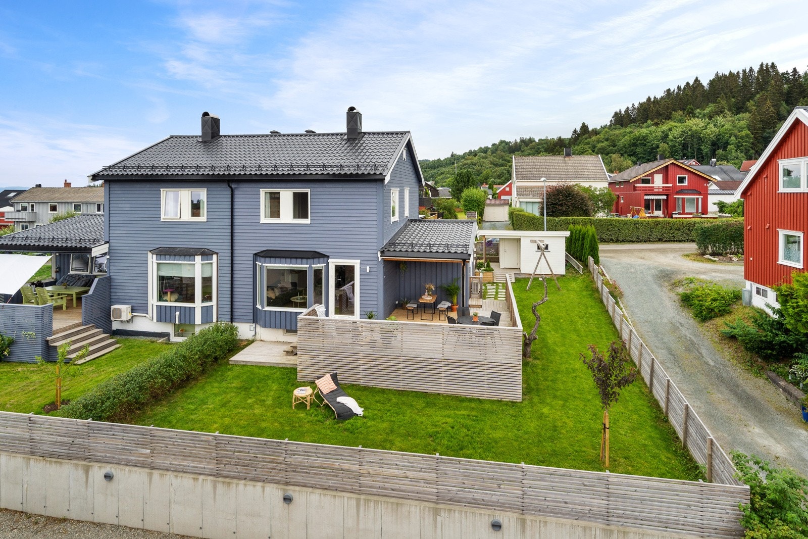 Boligen ligger pent og skjermet til, omgitt av en flat og frodig tomt. Tomten er naturlig adskilt fra naboen, med velstelt hekk Galleribilde