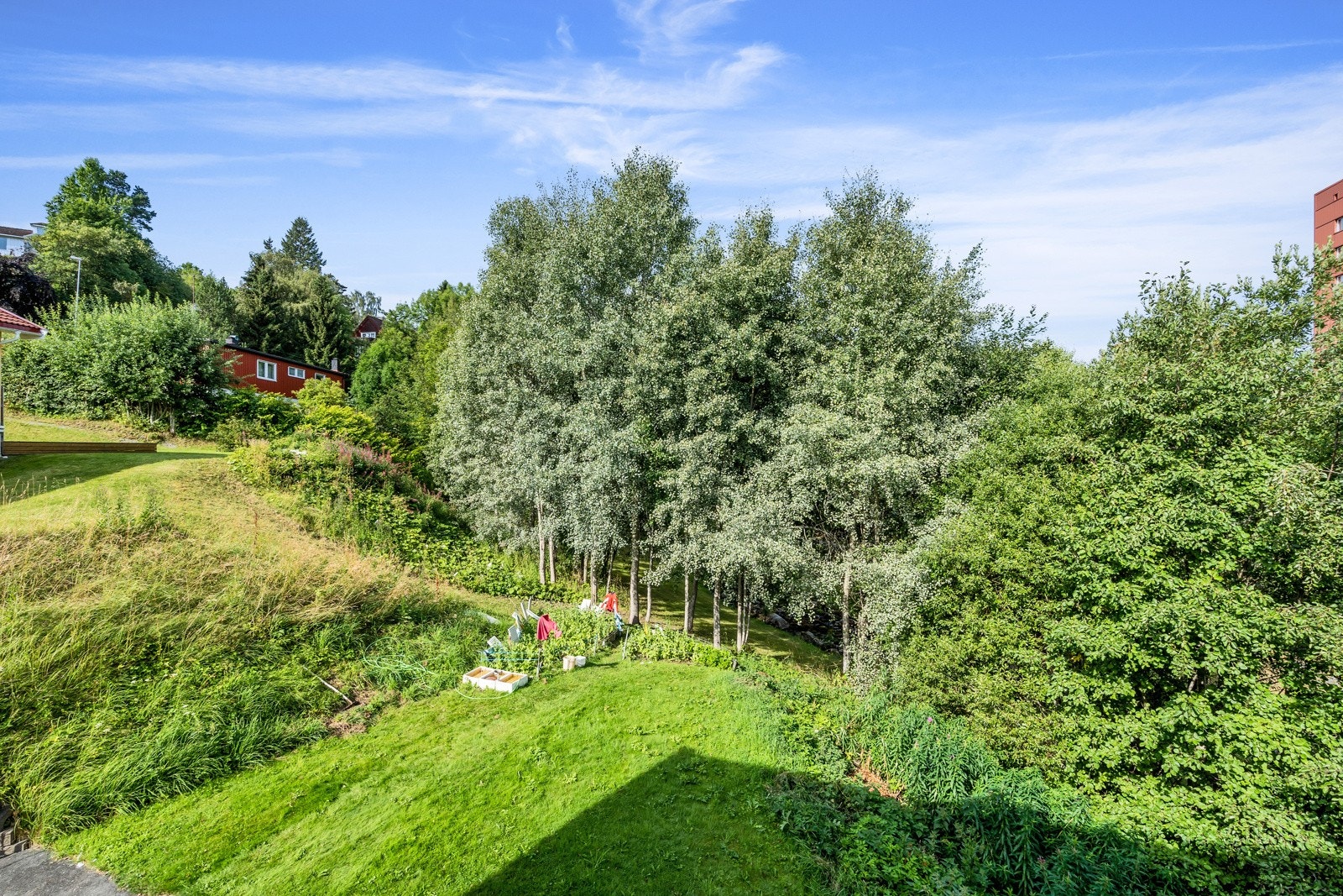 Fra kjøkkenet har du utsikt over tomtens frodige grøntarealer Galleribilde