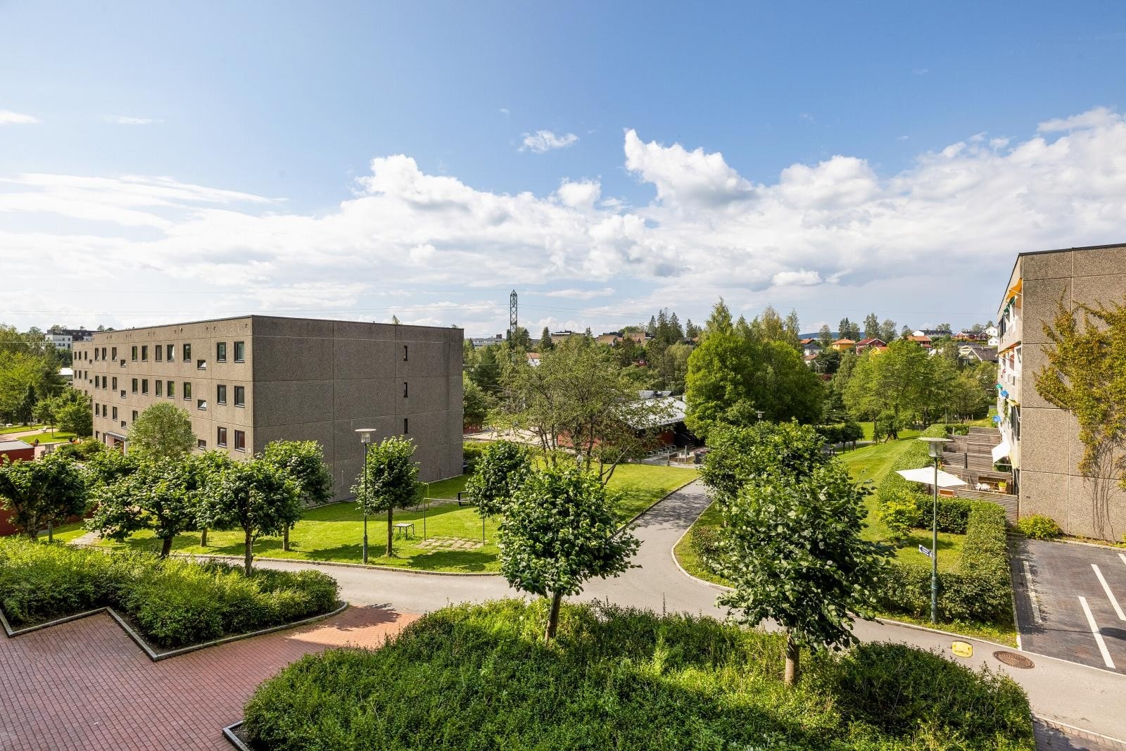 Her finnes velstelte plenarealer, asfalterte internveier og gjesteparkeringsplasser, samt bed, ulike prydbusker og fullvoksne trær Galleribilde