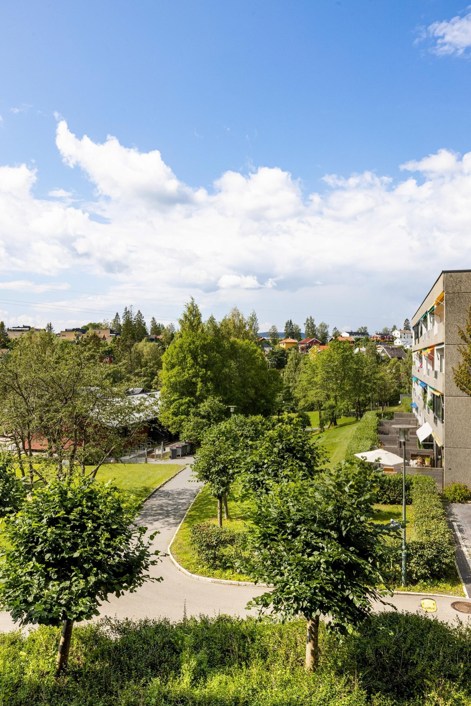 Fra balkongen er det fint utsyn over pent opparbeidede fellesarealer og videre ut mot Mærradalen Galleribilde