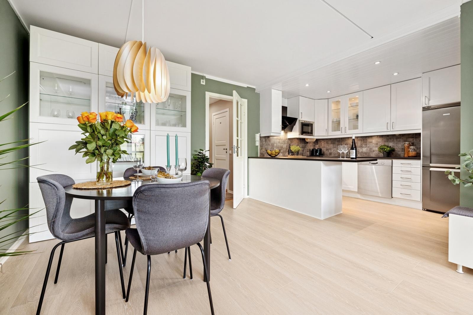 Lyst og moderne kjøkken i åpen løsning mot spisestuen Galleribilde