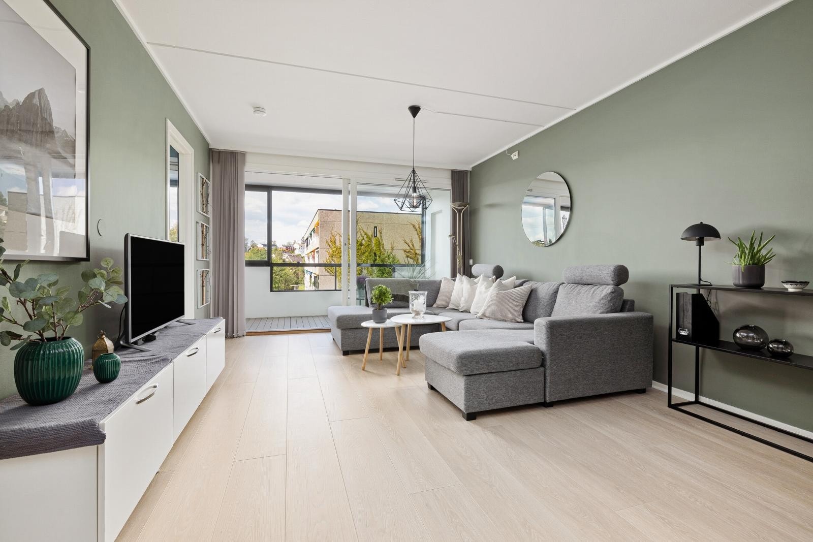 Til den stilfulle stuen er det rikelig lysinnslipp fra vestvendte vindusflater, og fra stor, dobbel skyvedør ut mot balkongen Galleribilde