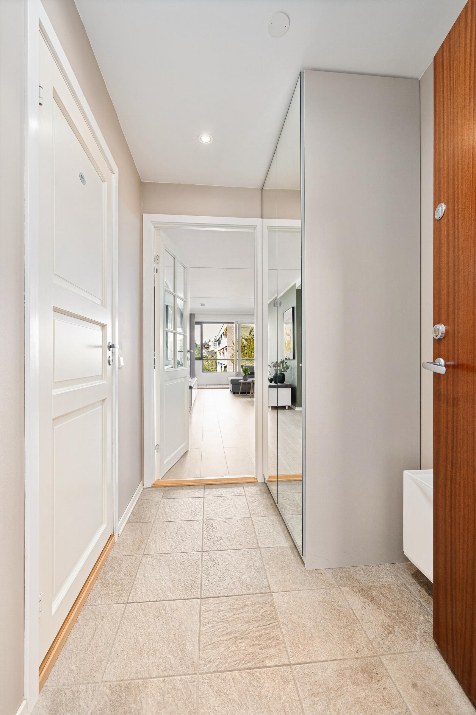 Lys og hyggelig entré med fliser på gulv og malt gipshimling i entré med downlights. Dørcalling m/skjerm Galleribilde