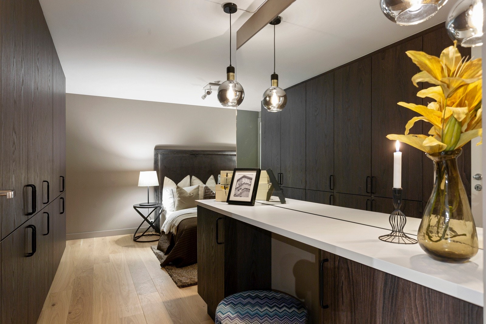 Hovedsoverommet har takhøye garderobeskap fra HTH i mørkebrun trestruktur, stilig plassbygd sminkebord og stort veggspeil Galleribilde