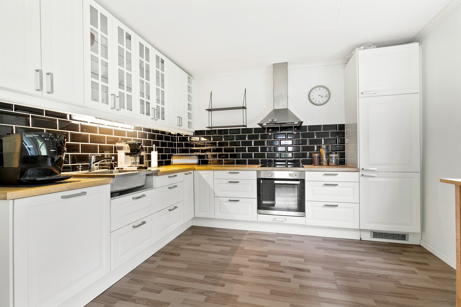 Kjøkkenet ligger i eget rom og har en klassisk innredning i hvitt, med profilerte fronter og glasskap. Det er godt med lagringsplass i takoppbygde overskap og rikelig med skap under benk. Galleribilde