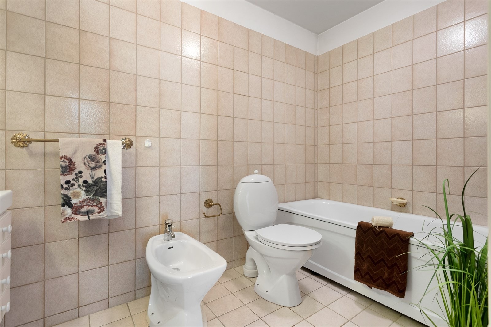 Badet har gulvstående toalett, dusjarmatur tilkoblet hånddusj og en separat dusjsone. Galleribilde