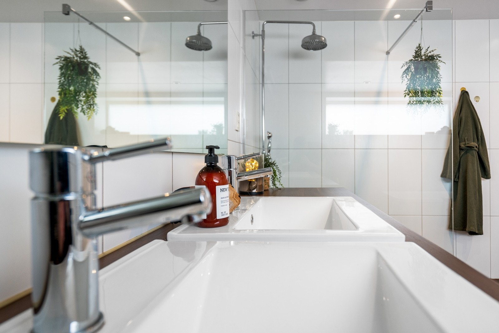 Videre er badet utstyrt med dobbelservant med speil over, gulvvarme, veggmontert toalett, badekar med stjernehimmel og et stort dusjhjørne. Galleribilde