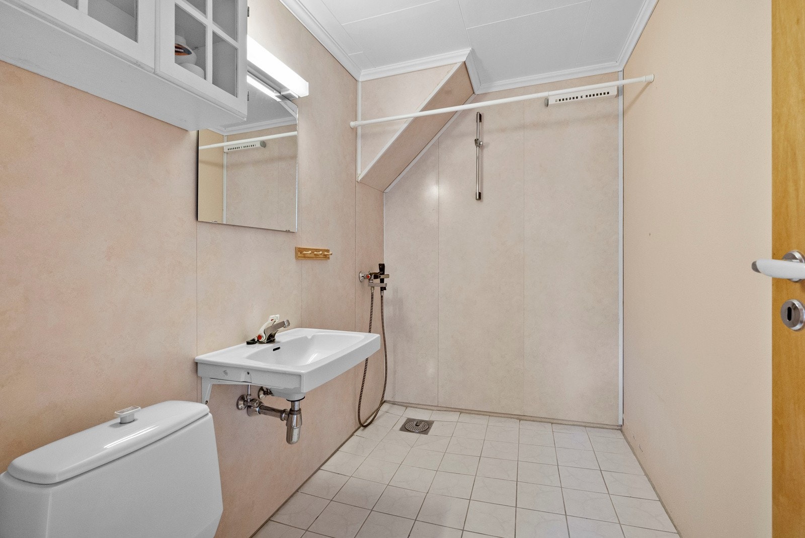 Badet i underetasjen. Badet er innredet med servant, veggskap, speil, dusj og frittstående toalett. Galleribilde