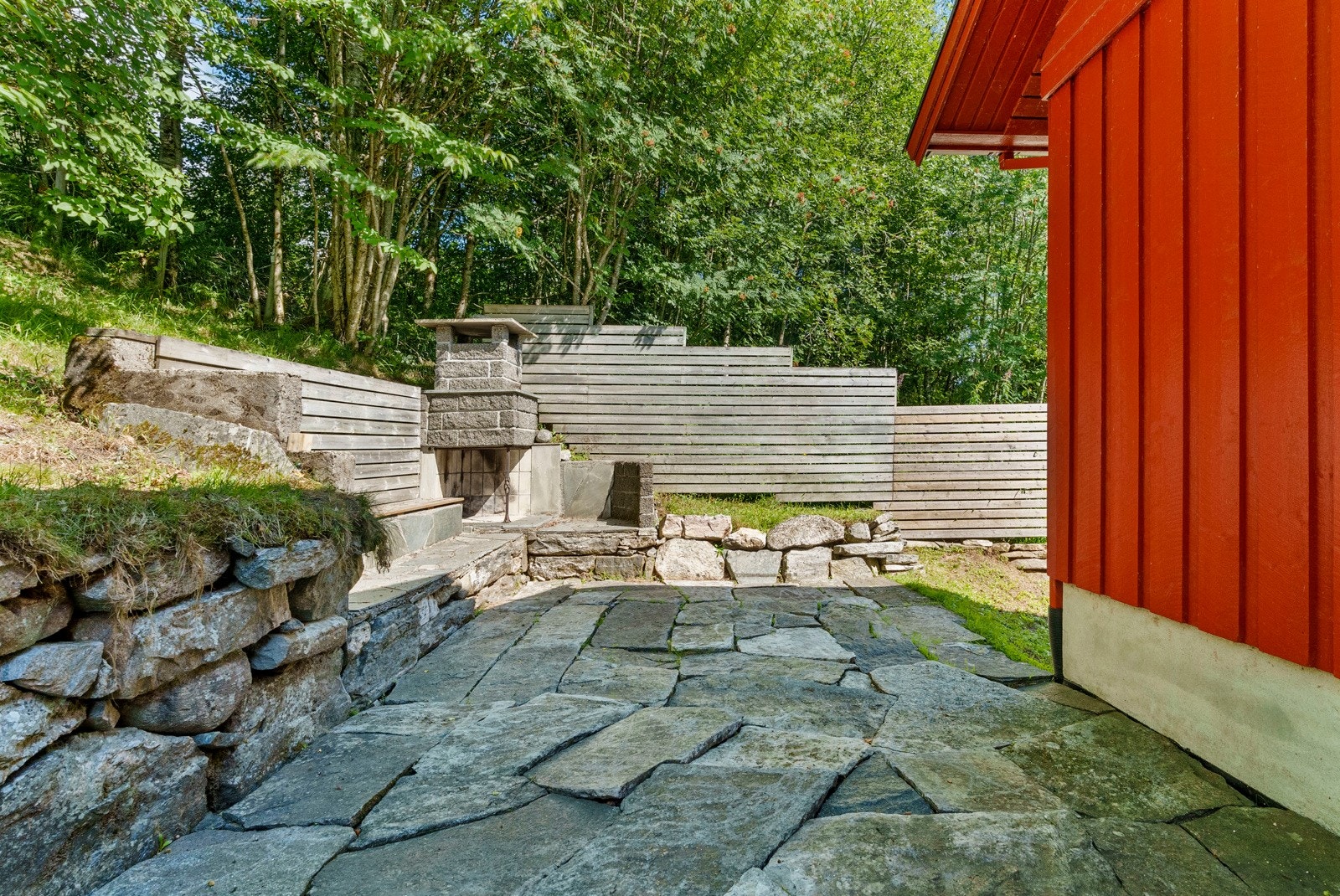 På nordøstsiden av boligen, like ved inngangspartiet er det laget til en fin utvendig sittegruppe med steinpeis. Galleribilde