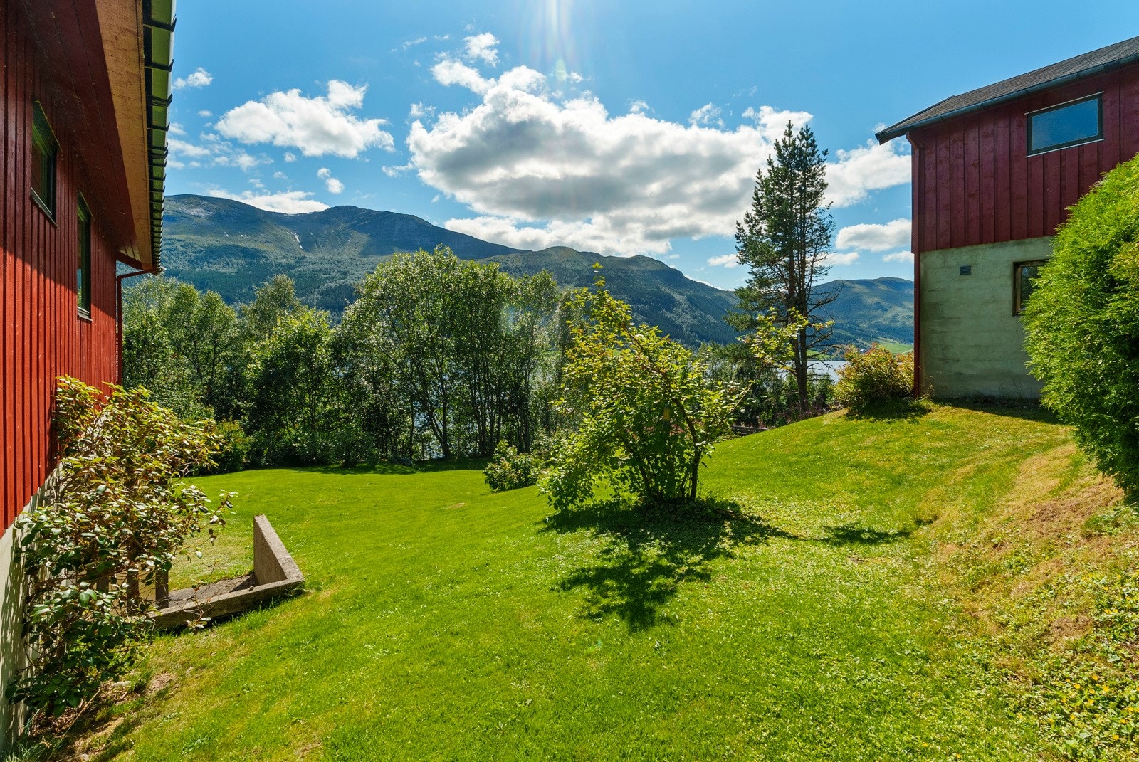 Hagen på vestsiden av boligen. Her finner du blant annet inngang til underetasjen til både boligen og garasje. Galleribilde