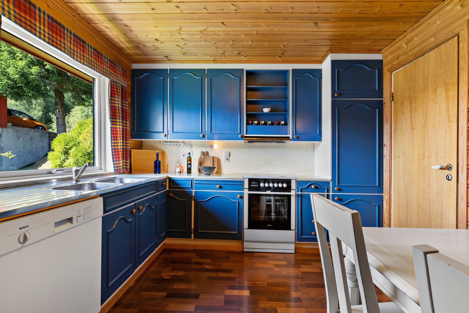 Romslig kjøkken like ved stuen. Plass til en mindre spisegruppe. Rommet er innredet med under- og overskap, benkeplate med oppvaskkum og frittstående hvitevarer. Galleribilde