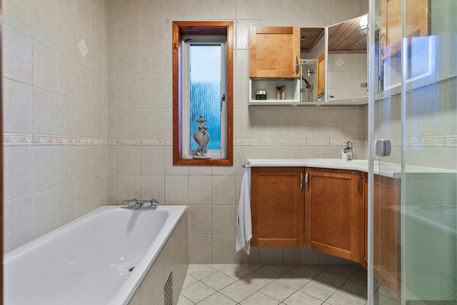 Flislagt bad i 1.etg med varme i gulv. Badet innehar en innredning med servant, badekar og en dusjnisje med glassdører. Galleribilde