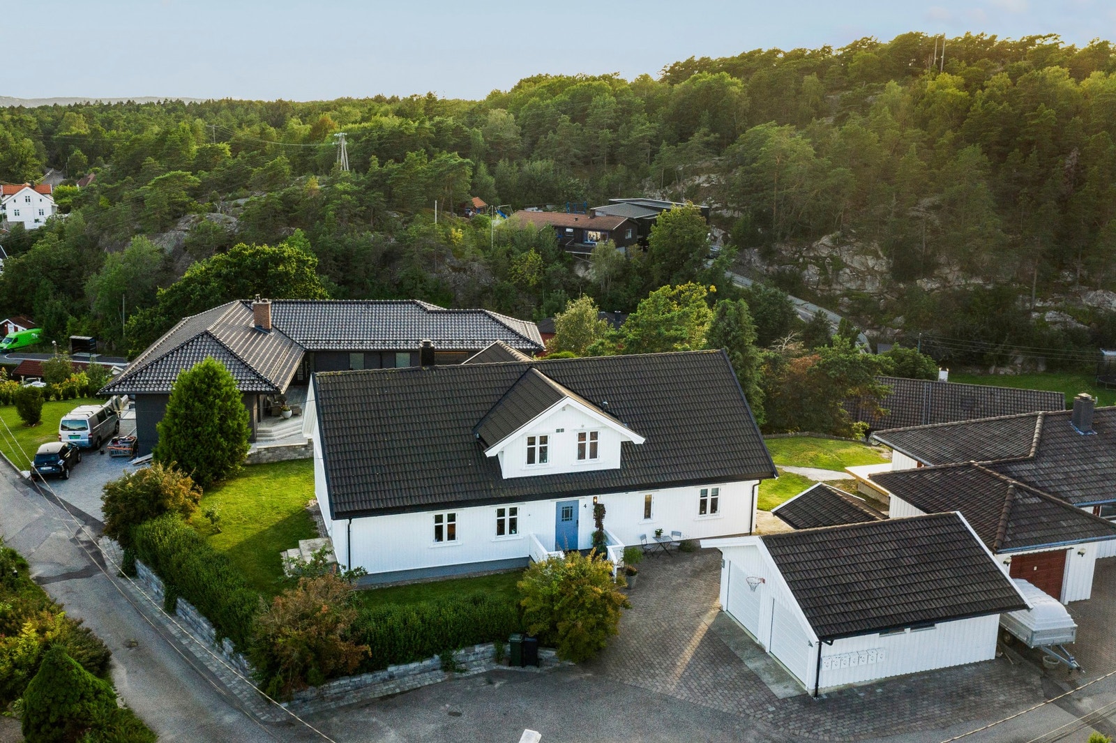 Tomten er pent opparbeidet med gressplen, busker og trær. Galleribilde