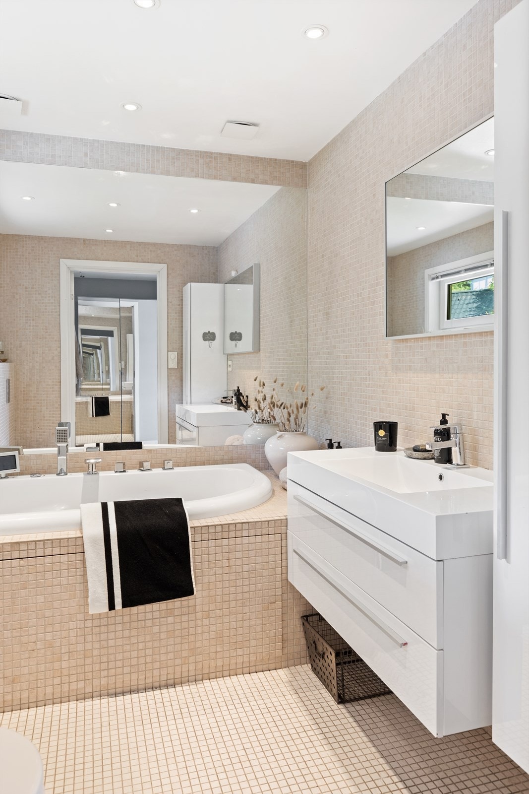 Pent baderom med tidløse mosaikkfliser. Speilet bak badekaret gir god romfølelse. Galleribilde