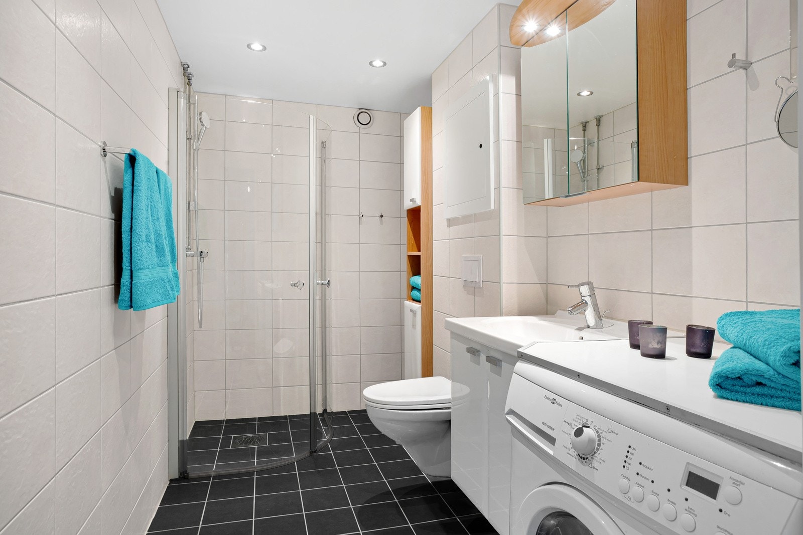 Pent og godt utnyttet bad med bl.a. opplegg for vaskemaskin, dusjnisje med innfellbare dører og oppbevaringsskap Galleribilde