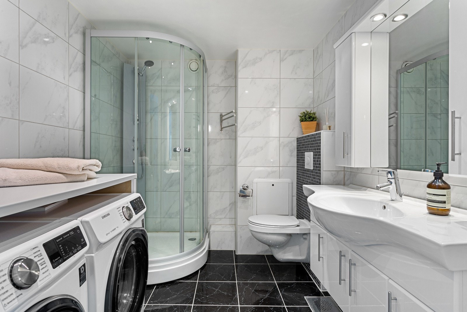 Det andre badet har et romslig dusjkabinett, i tillegg til opplegg for vaskemaskin og tørketrommel. Galleribilde