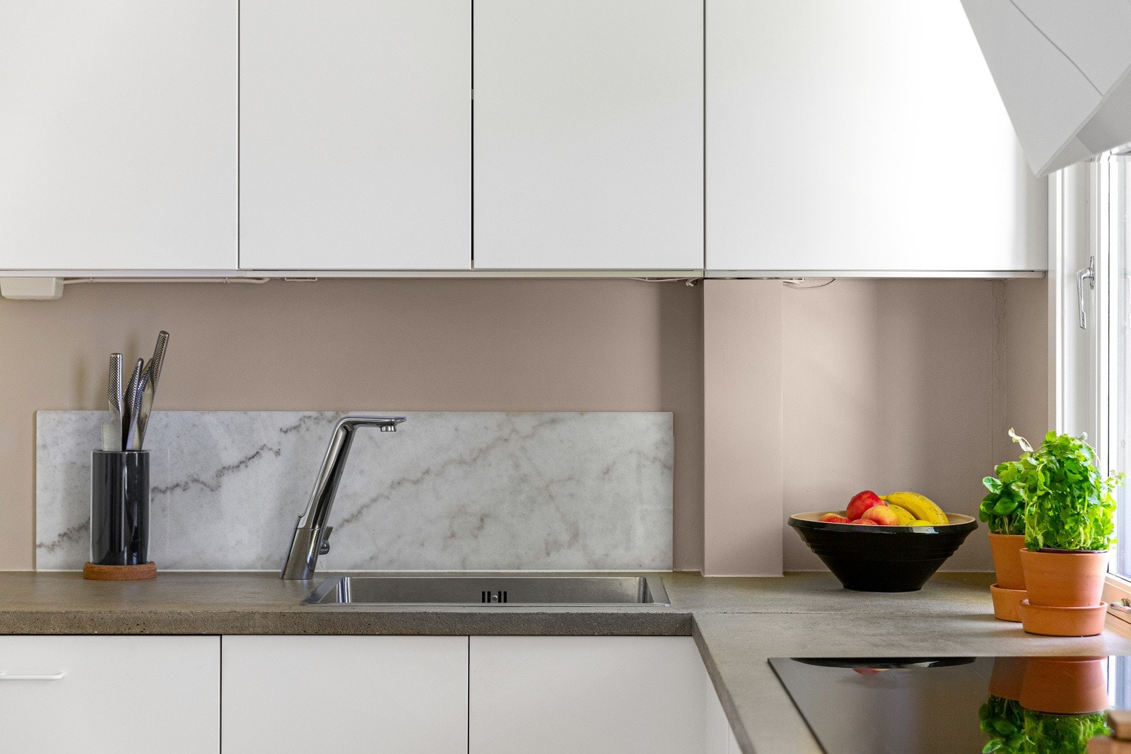 Kjøkkeninnredning fra IKEA montert i 2016, med hvite glatte fronter og benkeplate i betong med nedfelt oppvaskkum. Galleribilde